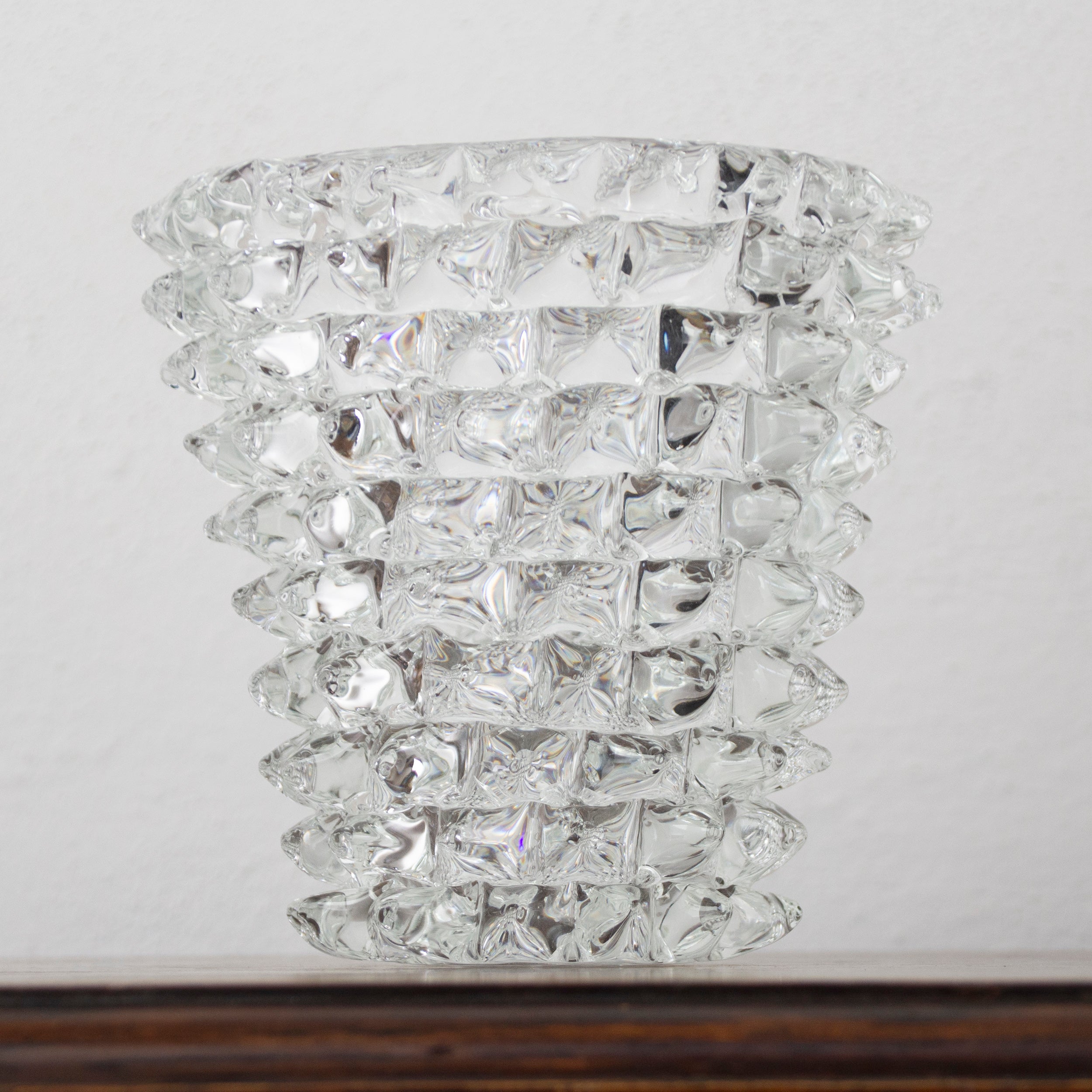Elegant clear Murano glass Rostrato vase by SoloCoseBelle, made in Italy, shown in a stylish furniture setting.