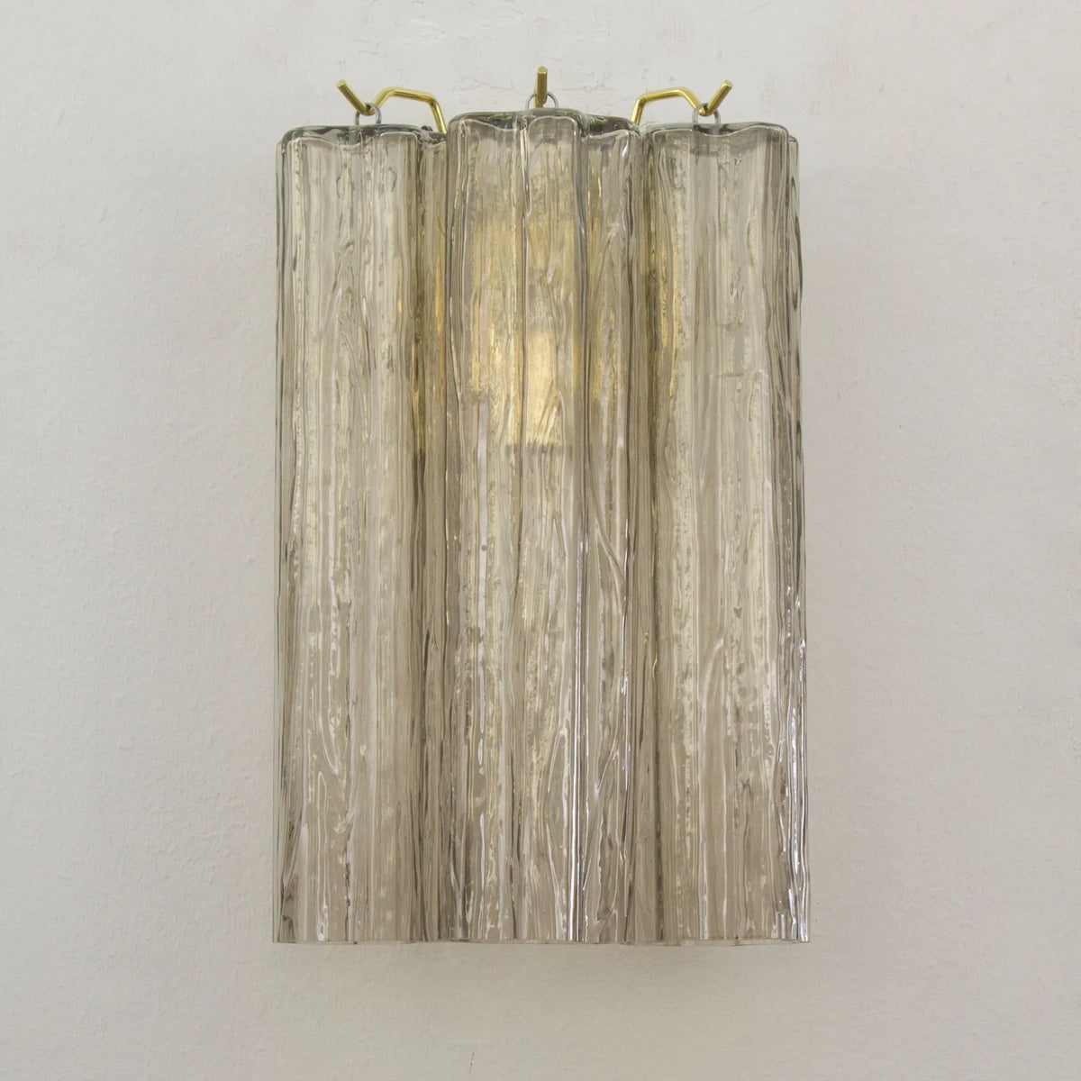 Single amber textured Murano glass wall sconce with three tube glasses and brass hooks, unlit