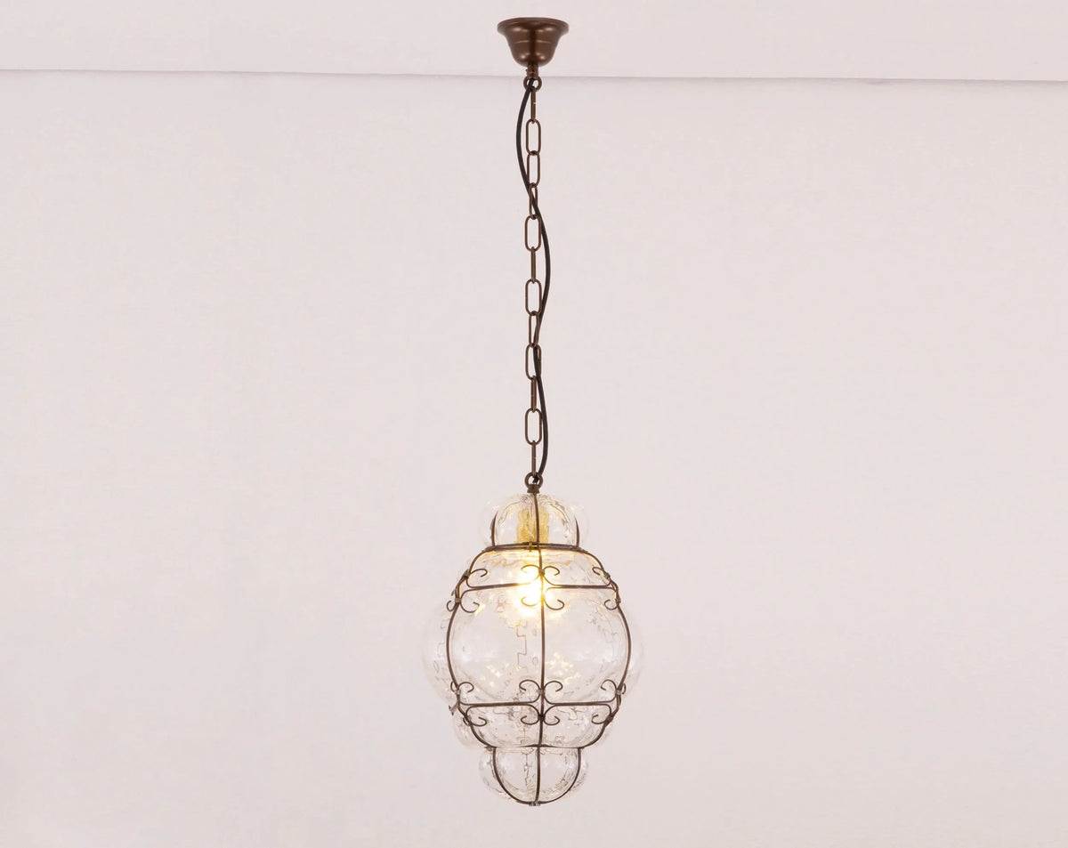 Clear Murano glass lantern pendant with scrollwork cage — illuminated front view