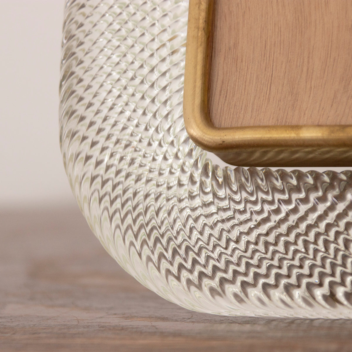 Close-up of the clear twisted Murano glass texture and brass inner border
