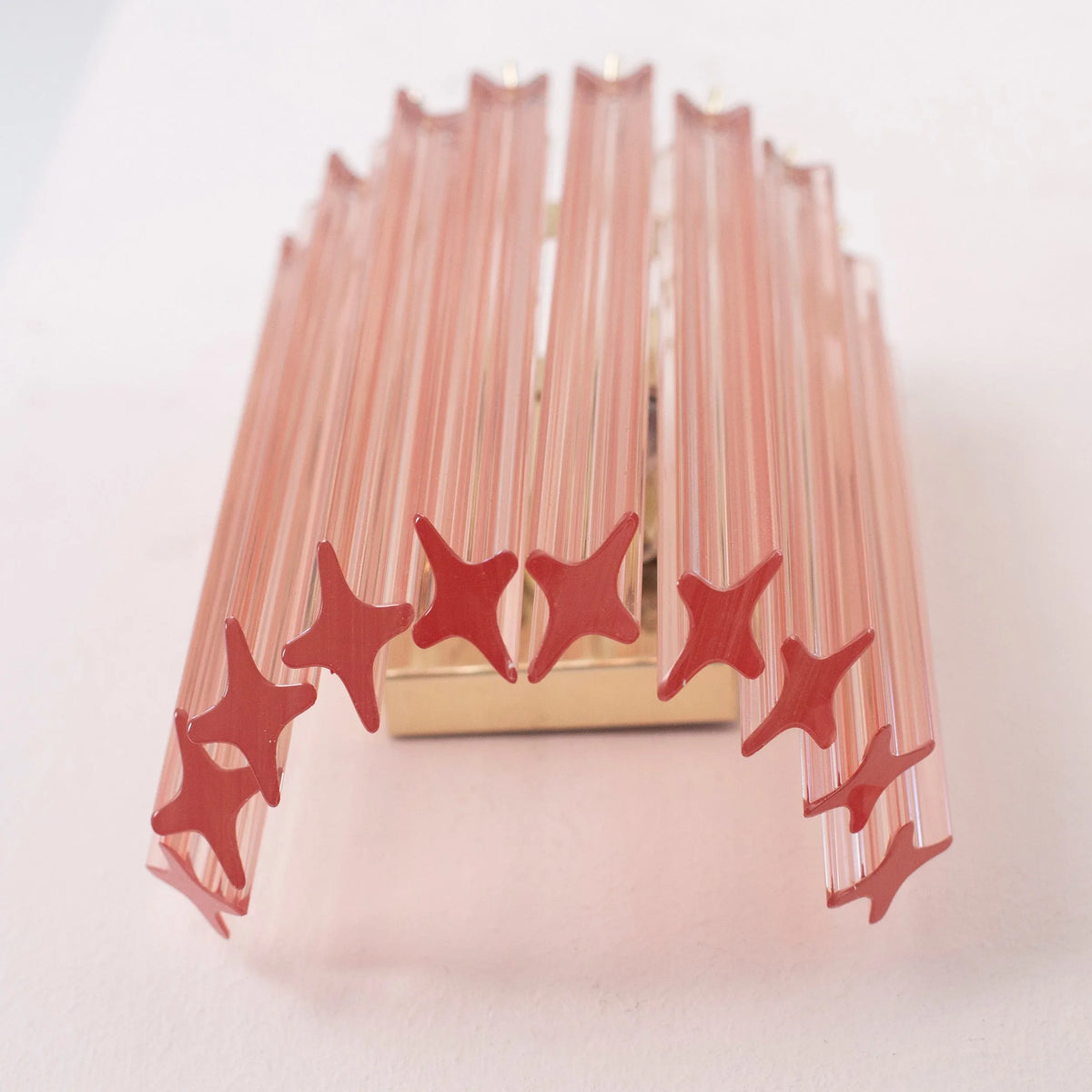 Pink Murano glass Quadriedri wall sconce seen from below, showing the star-shaped prism ends