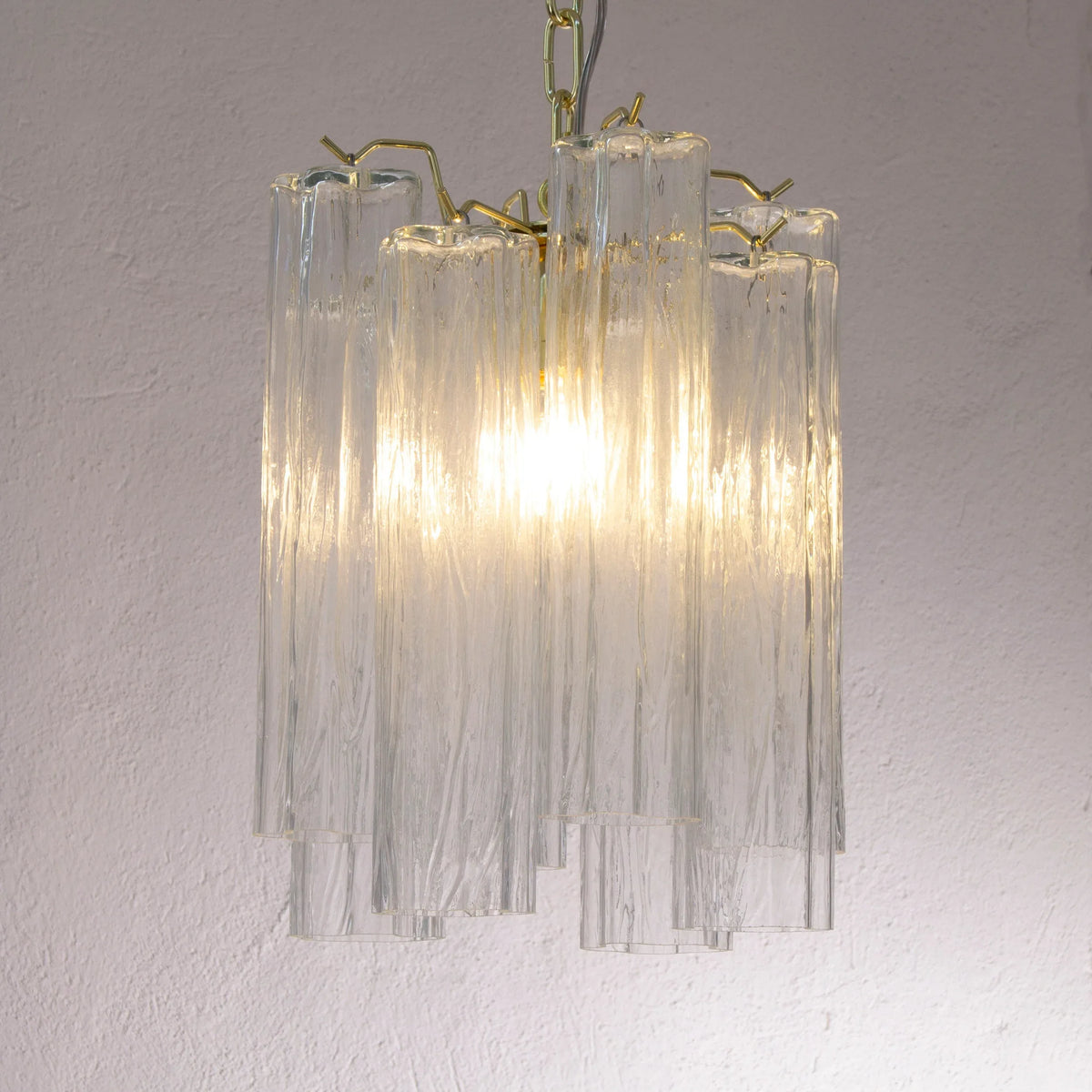 Small clear Tronchi Murano glass pendant — illuminated angled view