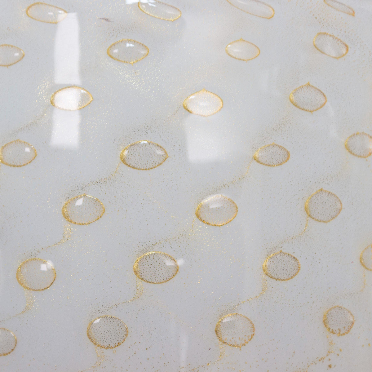 Close-up of the gold leaf bubble pattern on unlit white Murano glass